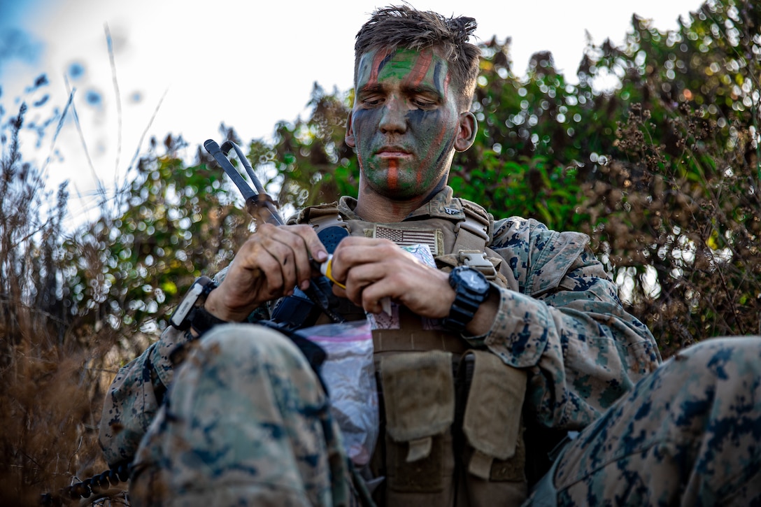 U.S. Marine Corps Cpl. Marshall Porritt, a platoon sergeant, with 2nd Battalion, 5th Marine Regiment, 1st Marine Division, finishes applying face paint during a Marine Corps Combat Readiness Evaluation (MCCRE) on Marine Corps Base Camp Pendleton, California, Sept. 24, 2019. 5th Marines conducted a regimental-sized MCCRE for 1st Battalion, 5th Marines and 2nd Battalion, 5th Marines, as well as the Regimental Headquarters to increase the combat proficiency and readiness of the regiment. The MCCRE took place over a 10 day period and served as proof of concept for future regimental-sized MCCREs. (U.S. Marine Corps photo by Lance Cpl. Roxanna Ortiz)