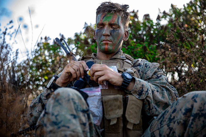 U.S. Marine Corps Cpl. Marshall Porritt, a platoon sergeant, with 2nd Battalion, 5th Marine Regiment, 1st Marine Division, finishes applying face paint during a Marine Corps Combat Readiness Evaluation (MCCRE) on Marine Corps Base Camp Pendleton, California, Sept. 24, 2019. 5th Marines conducted a regimental-sized MCCRE for 1st Battalion, 5th Marines and 2nd Battalion, 5th Marines, as well as the Regimental Headquarters to increase the combat proficiency and readiness of the regiment. The MCCRE took place over a 10 day period and served as proof of concept for future regimental-sized MCCREs. (U.S. Marine Corps photo by Lance Cpl. Roxanna Ortiz)