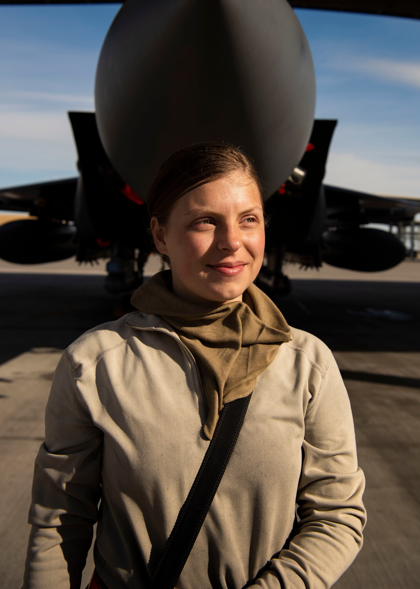 U.S. Air Force Airman 1st Class Kristin Lyons, 391st Fighter Squadron crew chief, stands by an F-15E Strike Eagle at the end of a 12-hour shift, April 14, 2020, at Mountain Home Air Force Base, Idaho. To increase safety of Airmen during the COVID-19 pandemic, the 391st FS has divided into teams, created an adjusted schedule and implemented CDC safety measures. (U.S. Air Force photo by Airman 1st Class Andrew Kobialka)