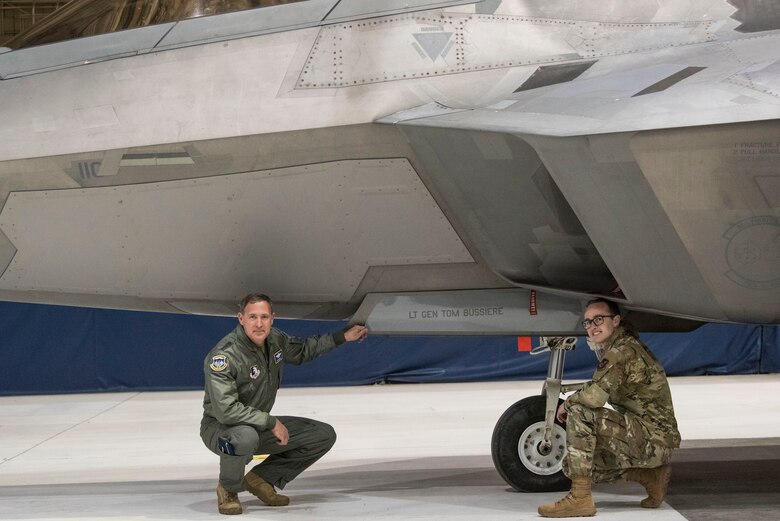 U.S. Air Force Lt. Gen. David A. Krumm, commander of Alaskan North American Aerospace Defense Command Region, Alaskan Command, and Eleventh Air Force, unveils his name with Air Force Tech. Sgt. Cody Rock, 90th Aircraft Maintenance Unit dedicated crew chief, during a flagship renaming ceremony April 20, 2020, at Joint Base Elmendorf-Richardson, Alaska. The newly painted F-22 Raptor flagship marks Krumm as the new commander.