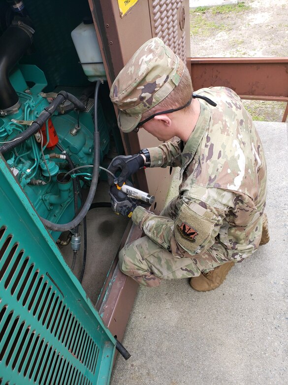 Photo of an Airman collecting an oil sample.