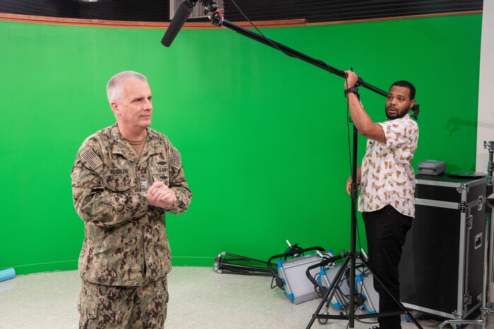 Code 1170 Videographer Alim Jordan sets up the microphone for Deputy Shipyard Commander Capt. Dan Rossler before he films a video regarding tips for minimizing the spread of COVID-19.