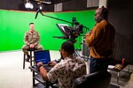 Code 1170 Videographers Greg Boyd and Alim Jordan set up the teleprompter to film NNSY Commander Capt. Kai Torkelson as he shares the latest COVID-19 update with the workforce.