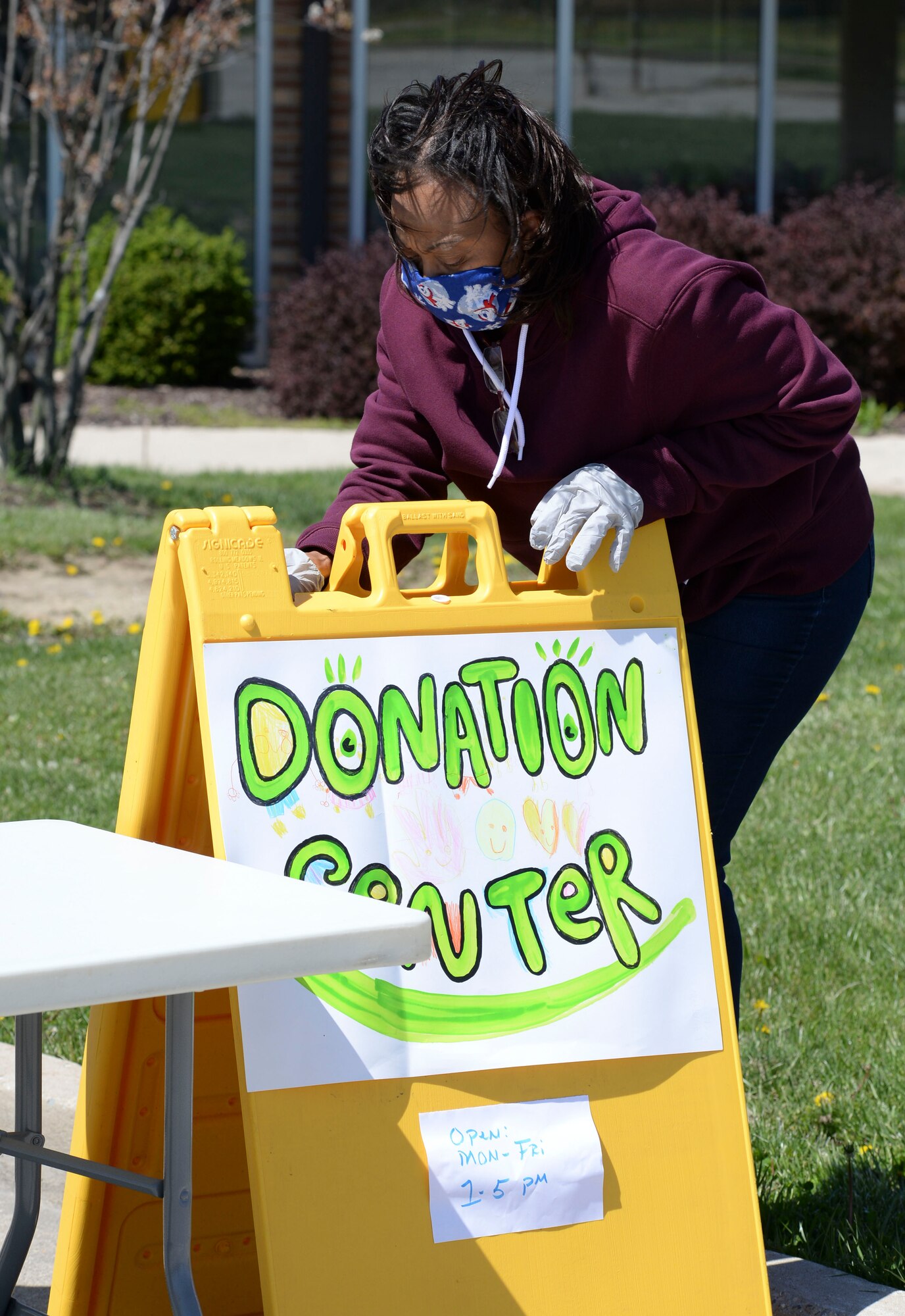 Bernadette Worsham, 88th Air Base Wing donation coordinator, sets up a sign for the 88th Air Base Wing’s donation drop off point outside the chapel located in the Prairies housing area at Wright-Patterson Air Force Base, Ohio, April 21, 2020. The center is open Monday-Friday between 1 and 5 p.m. (U.S. Air Force photo/Wesley Farnsworth)