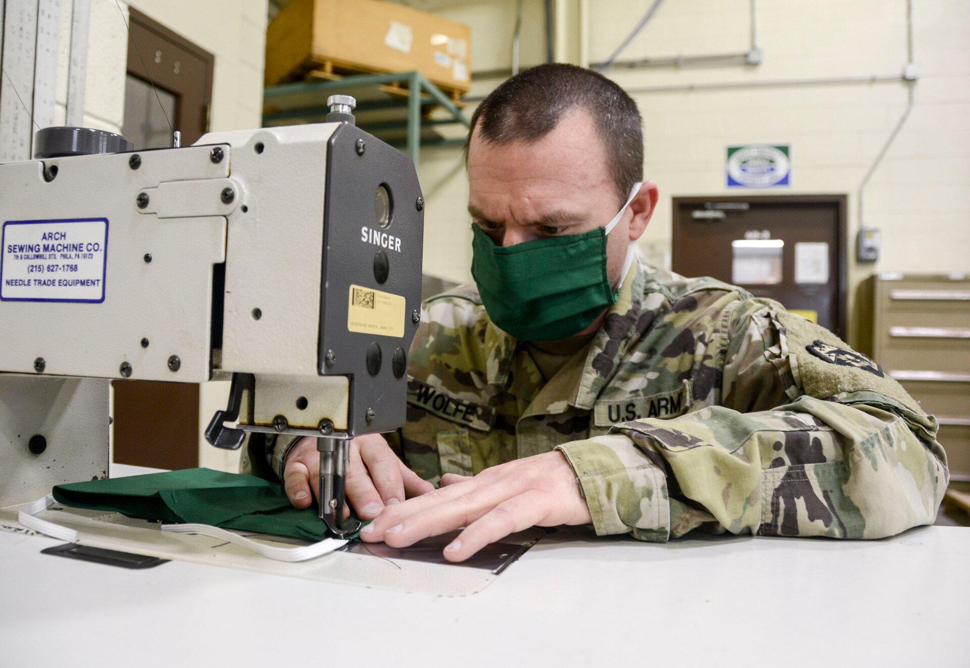 Staff Sgt. Arthur Wolfe, a canvas worker at the Combined Maintenance Support Shop-East  at Fort Indiantown Gap and member of the 3622nd Support Maintenance Company, 728th Combat Sustainment Support Battalion, 213th Regional Support Group, sews in the elastic ear straps to finish a cloth mask on April 21, 2020. Several Pennsylvania Army National Guard Soldiers with CSMS-East began producing cloth masks to protect Guard members during the ongoing COVID-19 pandemic here starting April 16. (U.S. Army National Guard photo by Staff Sgt. Zane Craig)