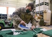 Spc. Nick Ernesto, a woodworker at the Combined Maintenance Support Shop-East at Fort Indiantown Gap and member of the 3622nd Support Maintenance Company, 728th Combat Sustainment Support Battalion, 213th Regional Support Group irons material that will be used to produce a cloth mask for Guardsmen. Several Pennsylvania Army National Guard Soldiers with the CSMS-East began producing cloth masks to protect Guard members during the ongoing COVID-19 pandemic here starting April 16. (U.S. Army National Guard photo by Staff Sgt. Zane Craig)