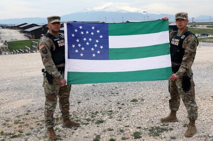 New York Army Reserve Sgt. Justen Fernandez and Sgt. Louis Li fly the New York Police Department flag April 14, 2020, at Camp Bondsteel, Kosovo, where they are deployed in support of the NATO-led Kosovo Force mission. Fernandez and Li are full-time NYPD officers and members of the New York Army Reserve’s 423rd Military Police Company.