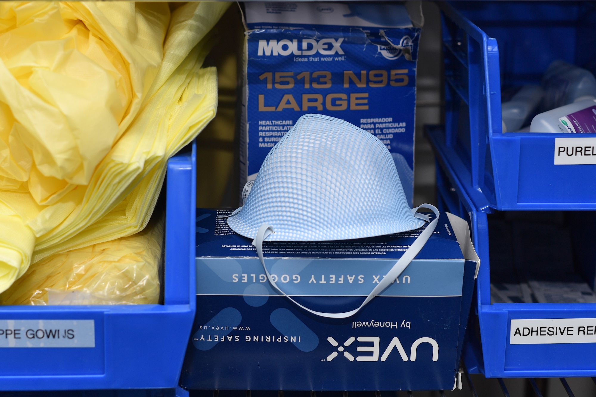 A medical mask and other personal protective equipment is shown sitting on a shelf.