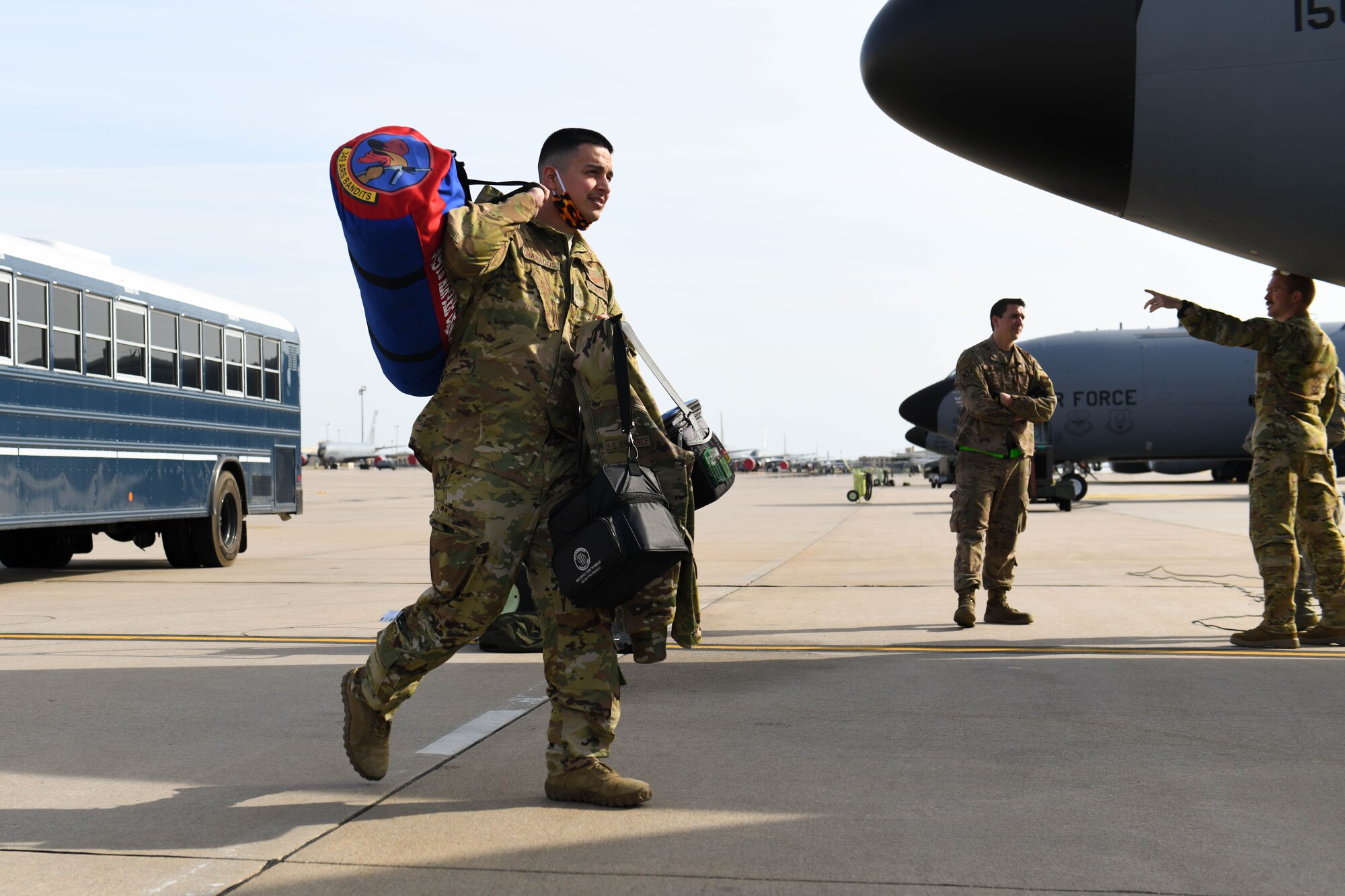 Senior Airman Joshua Granados, 349th Air Refueling Squadron boom operator, carries his personal belongings to a KC-135 Stratotanker Apr. 9, 2020, at McConnell Air Force Base, Kansas. In order to support ongoing air refueling operations, each aircraft was assigned a second augmented aircrew to take over operation of the aircraft during the second half of the flight to Qatar. (U.S. Air Force photo by Airman 1st Class Nilsa E. Garcia)