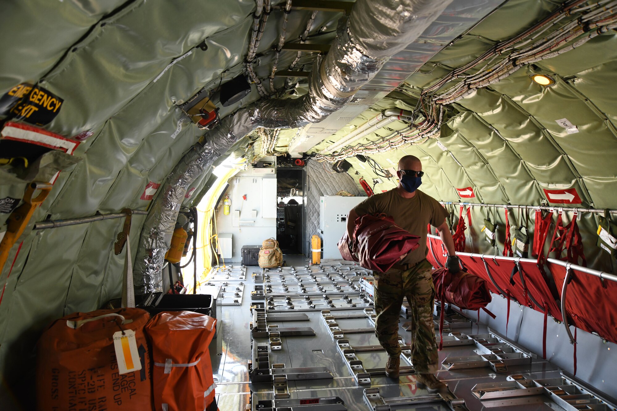 Tech. Sgt. Lucas Treat, 349th Air Refueling Squadron boom operator, carries engine covers in a KC-135 Stratotanker Apr. 8, 2020 at McConnell Air Force Base, Kansas. The deploying aircrew will fly a 16 hour direct flight to Al Udeid Air Base, Qatar. The KC-135 has the capability of traveling 1,500 miles with 150,000 pounds of transfer fuel. (U.S. Air Force photo by Airman 1st Class Nilsa E. Garcia)