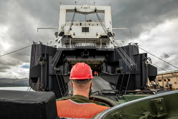 A U.S. Marine drives an amphibious assault vehicle onto the Watson-class vehicle cargo ship USNS Dahl during an operation to onload and offload equipment for construction of an Expeditionary Medical Facility April, 16.