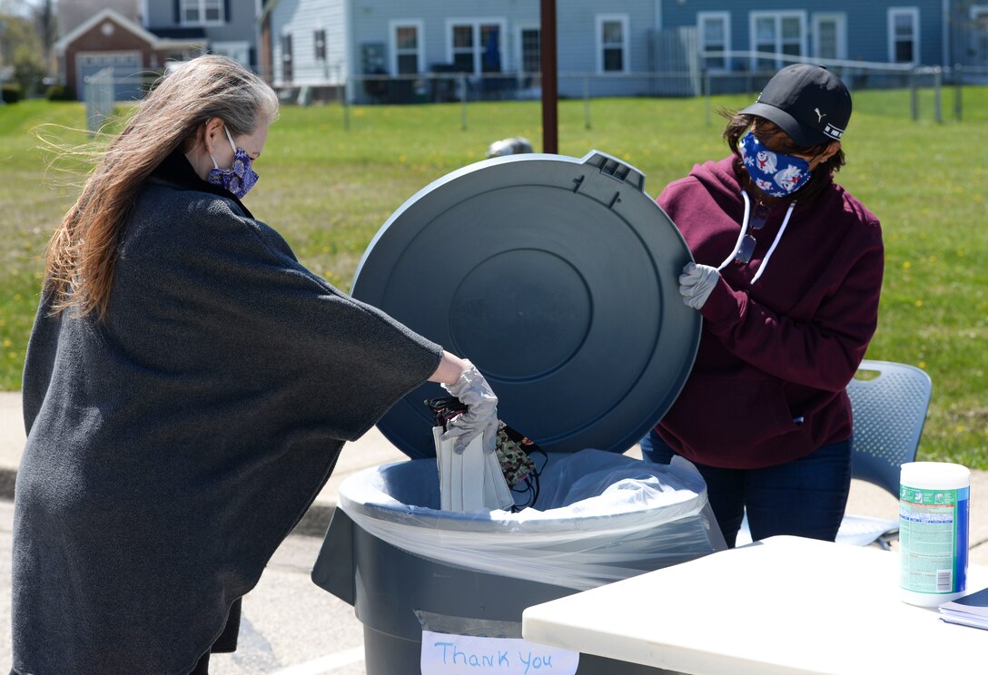 U.S. Air Force Chief Master Sgt. Jeannette Roman, 655th Intelligence, Surveillance and Reconnaissance Wing command chief liaison, drops a donation of masks into a collection bin, as Bernadette Worsham, 88th Air Base Wing donation coordinator holds the lid open, at the 88th Air Base Wing’s donation drop off point outside the chapel located in the Prairies housing area at Wright-Patterson Air Force Base, Ohio, April 21, 2020. (U.S. Air Force photo/Wesley Farnsworth)