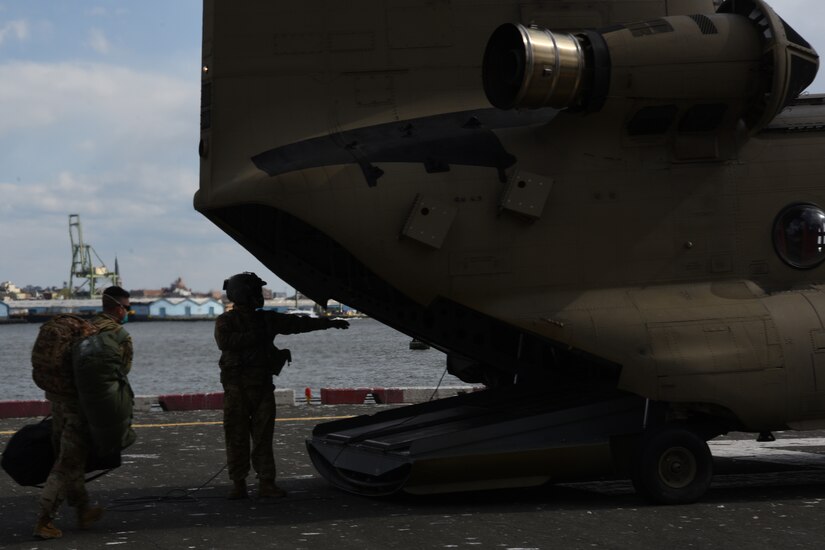 A soldier walks to a helicopter’s open cargo door.