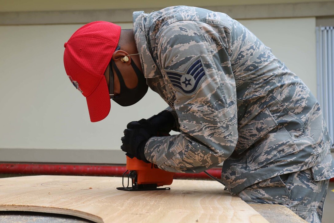 A guardsman cuts wood for a unit installation