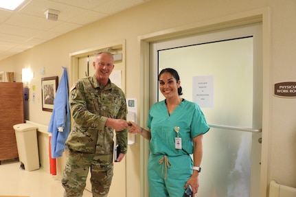 Gen. Randall Simmons, commander, Georgia Army National Guard, recognized Spc. Leslie Davila, a medic with the 2nd Battalion, 121st Infantry Regiment, 48th Infantry Brigade Combat Team, for her contributions to the fight against COVID-19 during a tour of the Phoebe Putney Memorial Hospital in Albany, Georgia, March 28, 2020. Davila and her son, also with the Guard, were both assigned as medics at the hospital.