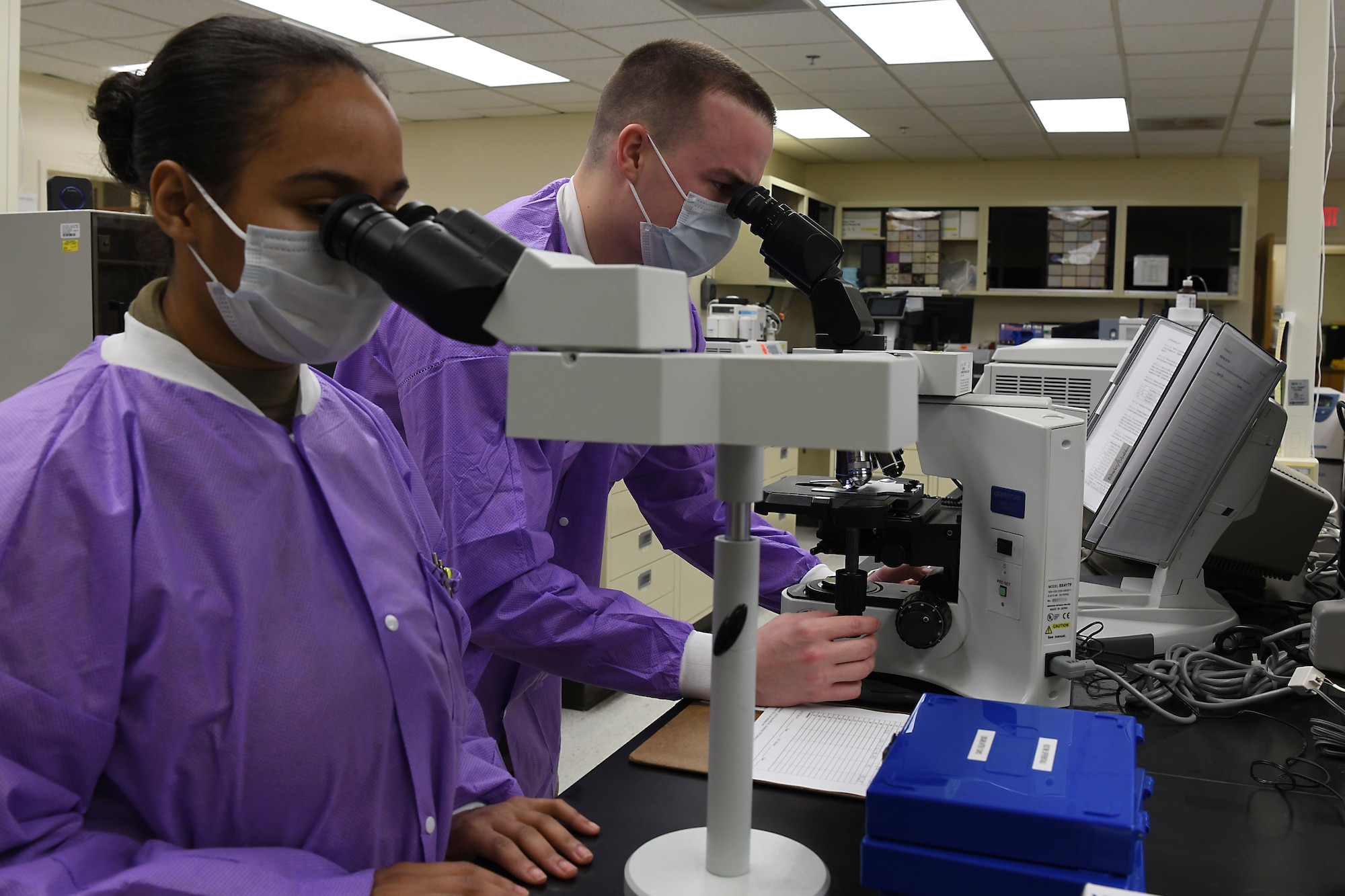Staff Sgt. Cody Emery and Airman 1st Class Jordan Cleveland, 30th Healthcare Operations Squadron laboratory technicians, conduct microscope training, April 20, 2020, at Vandenberg Air Force Base, Calif.