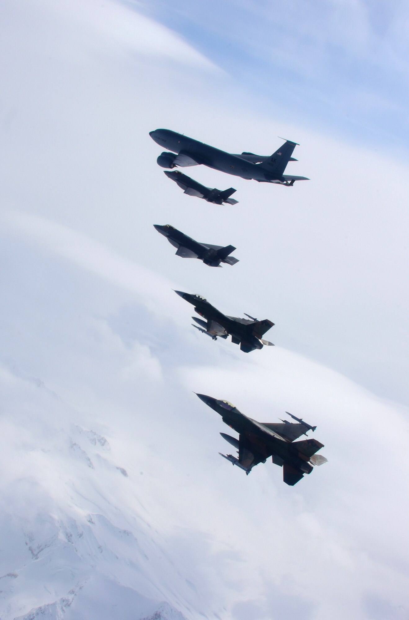 A five-ship formation of U.S. Air Force F-35A Lightning II and F-16C Fighting Falcon fighter aircraft, as well as a KC-135R Stratotanker fly over the Joint Pacific Alaska Range Complex April 21, 2020.