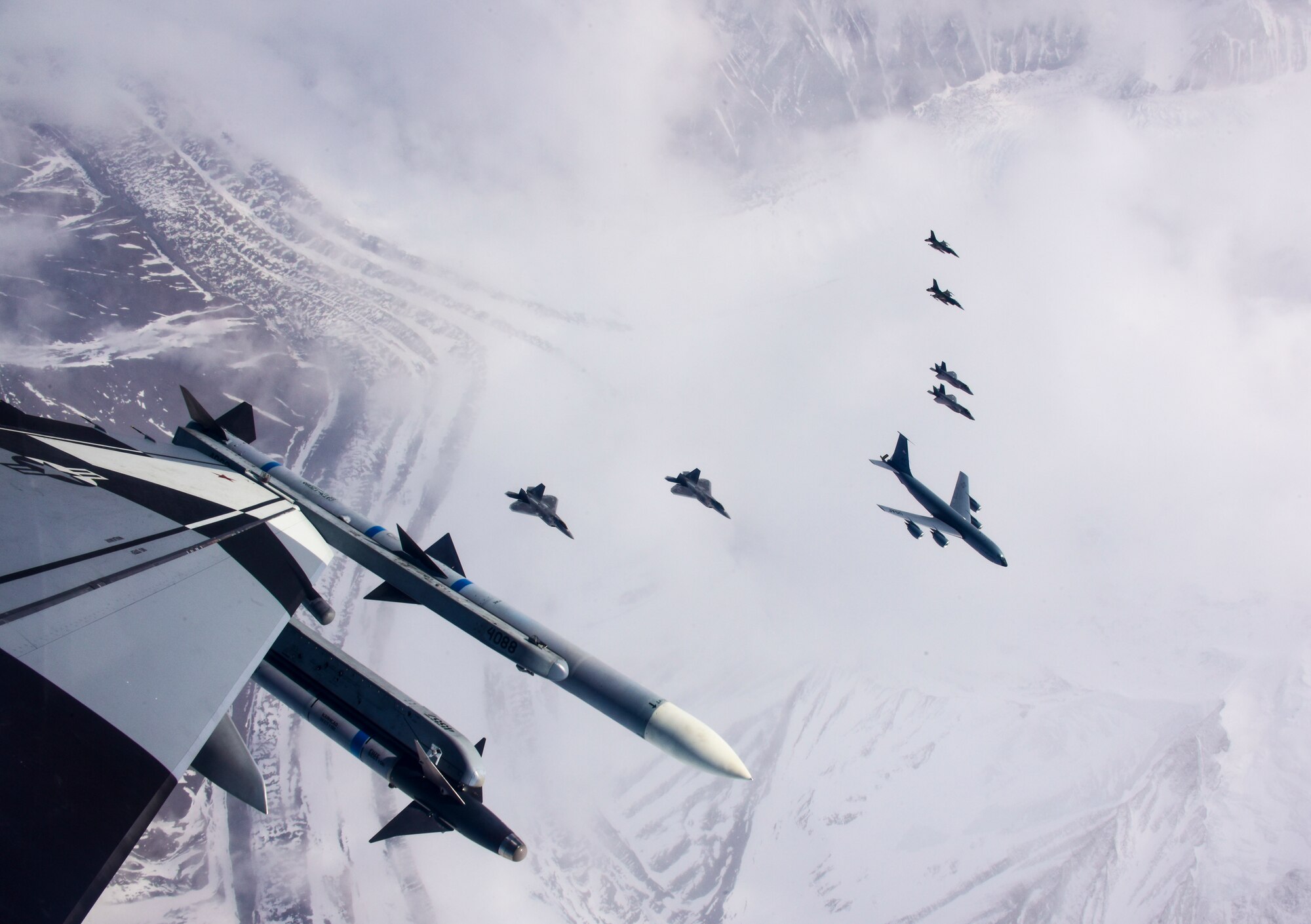 A seven-ship formation of U.S. Air Force F-35A Lightning II,  F-22 Raptor fifth-generation fighters, and F-16C Fighting Falcon fighter aircraft, as well as a KC-135R Stratotanker flies over the Joint Pacific Alaska Range Complex April 21, 2020.