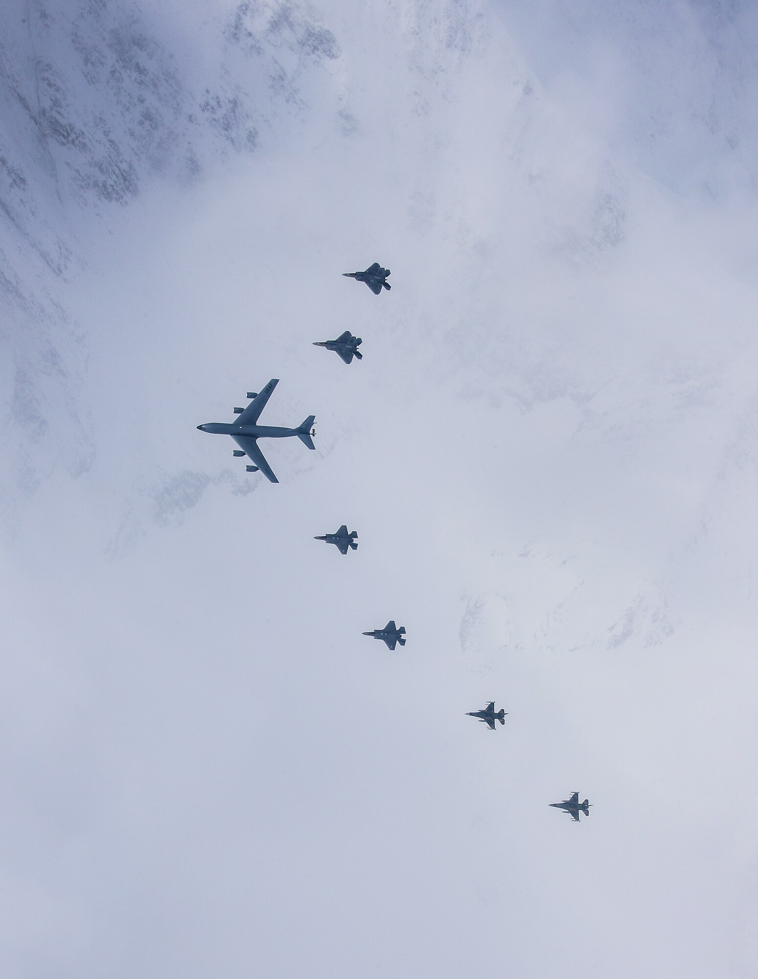 A seven-ship formation of U.S. Air Force F-35A Lightning II and F-22 Raptor fifth-generation fighters, F-16C Fighting Falcon fighters and a KC-135R Stratotanker flies over Alaska April 21, 2020.