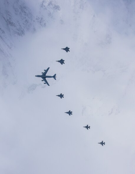 A seven-ship formation of U.S. Air Force F-35A Lightning II and F-22 Raptor fifth-generation fighters, F-16C Fighting Falcon fighters and a KC-135R Stratotanker flies over Alaska April 21, 2020.
