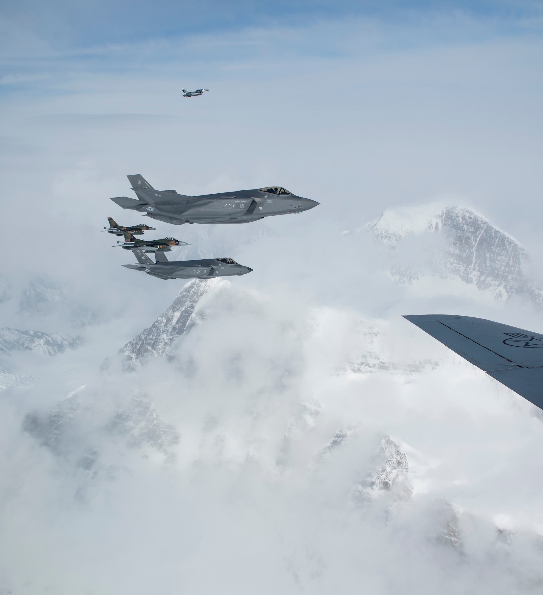 Two F-16C Fighting Falcons and two F-35A Lightning II aircraft from the 354th Fighter Wing, Eielson Air Force Base, Alaska, move into position to fly in formation off of a KC-135R Stratotanker from the 168th Wing, Alaska Air National Guard, Eielson AFB over the Alaska Range, April 21, 2020.