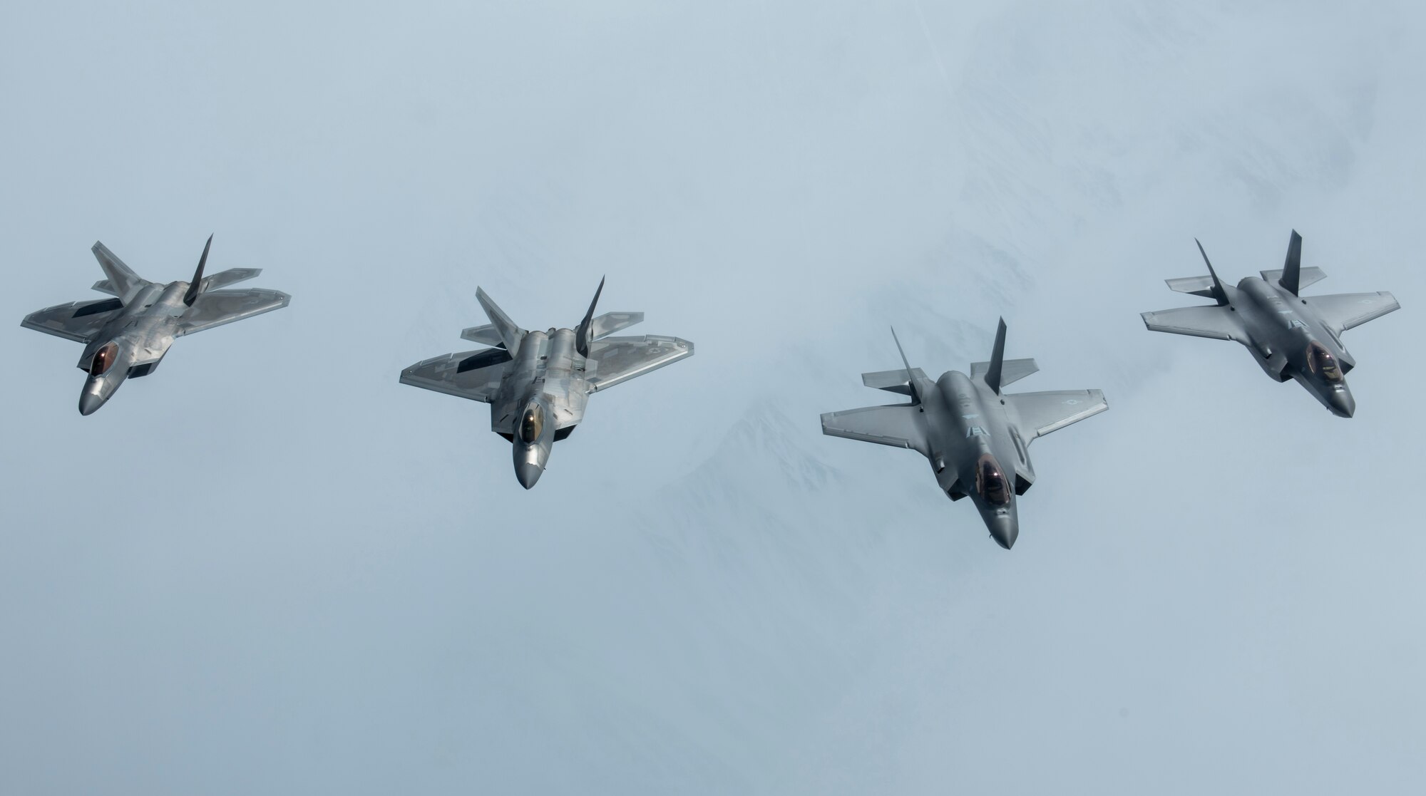 Two F-35A Lightning II aircraft, newly assigned to Eielson Air Force Base, Alaska, and two F-22 Raptors from Joint Base Elmendorf-Richardson, Alaska, fly in formation over the Alaska Range, April 21, 2020.