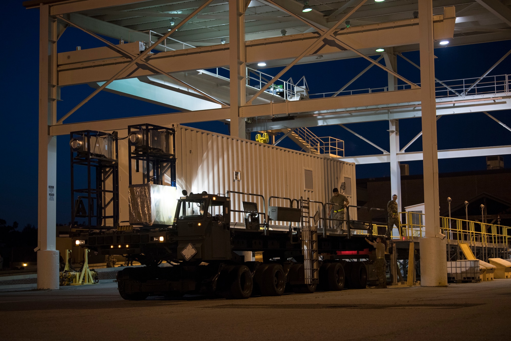 U.S. Airmen from the 437th Aerial Port Squadron use a K-Loader to move a Negatively Pressurized Conex prototype after it was delivered to Joint Base Charleston, S.C., April 21, 2020. The NPC will be tested for potential use as a transport module for individuals infected with the COVID-19 virus and other highly infectious diseases. (U.S. Air Force photo by Staff Sgt. Chris Drzazgowski)