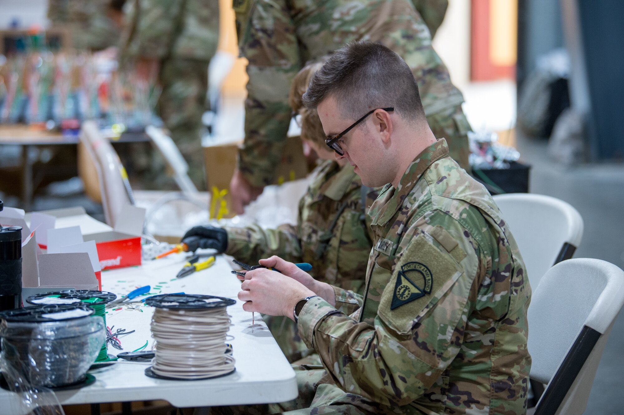 Soldiers from the Vermont Army National Guard assist in the construction of electrical components for a 400-bed medical health facility at the Champlain Valley Exposition.