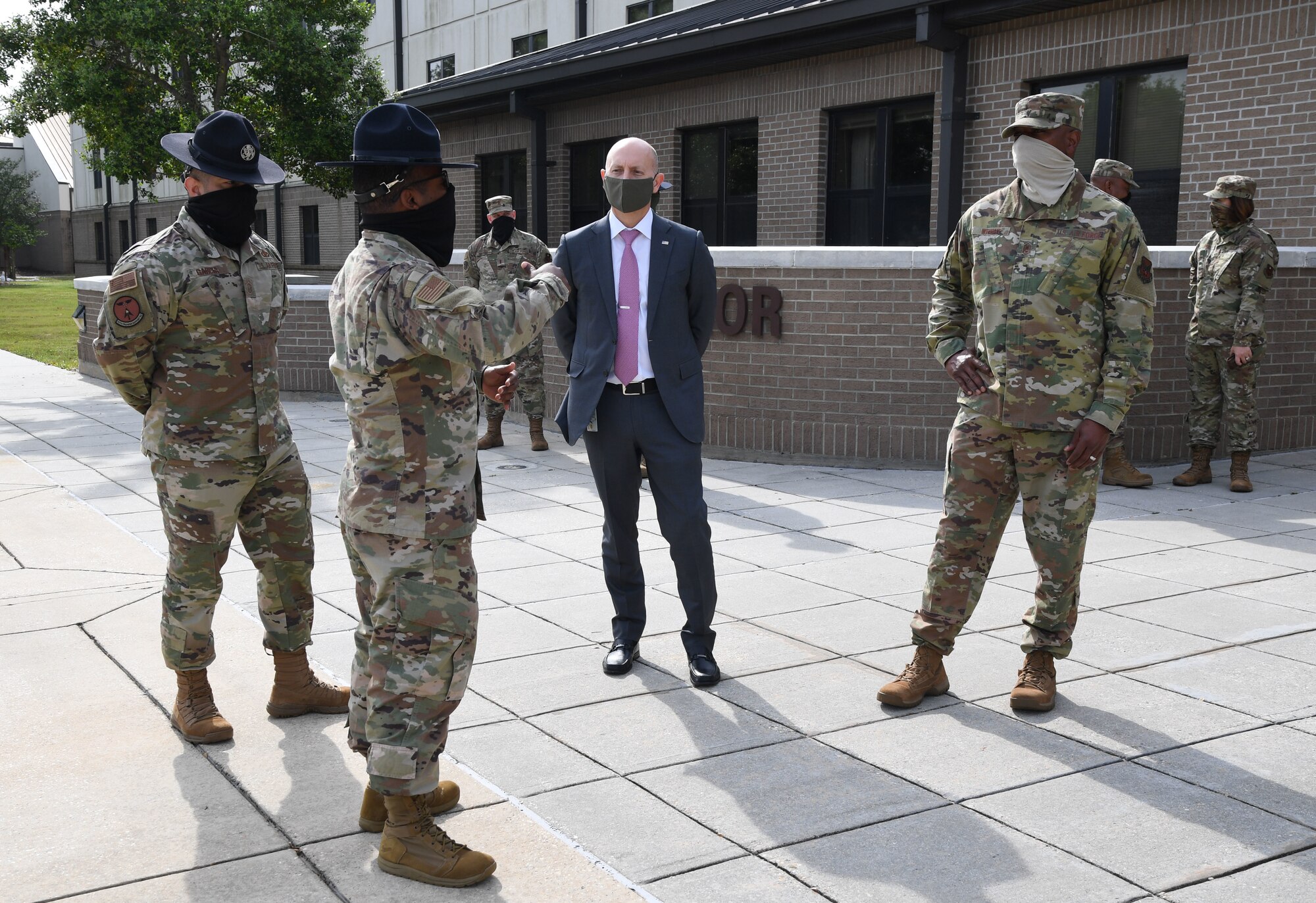 Airmen briefing visitors outside a building