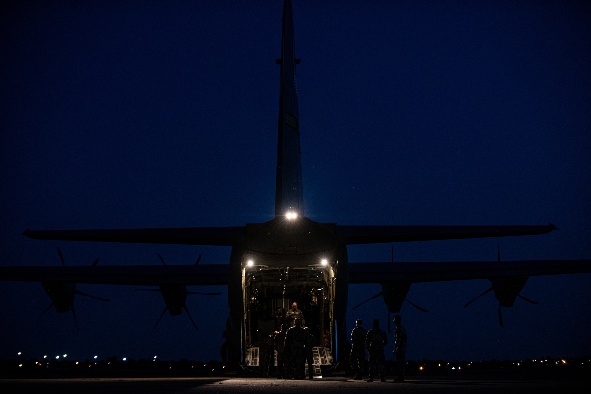 Airmen and Soldiers load cargo on a C-130J