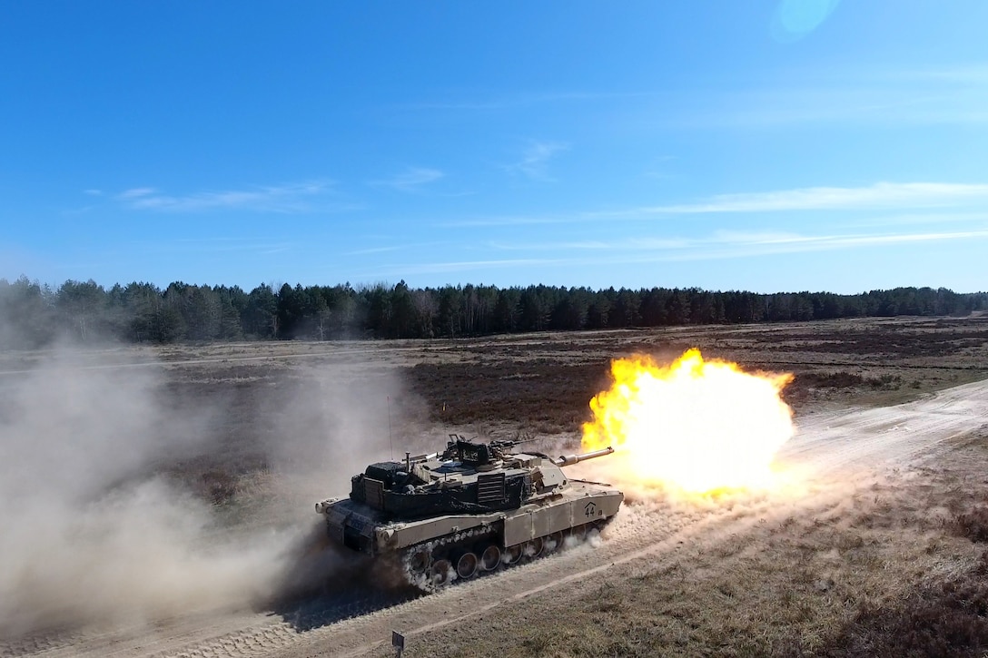 A tank fires an explosive round at a testing range.