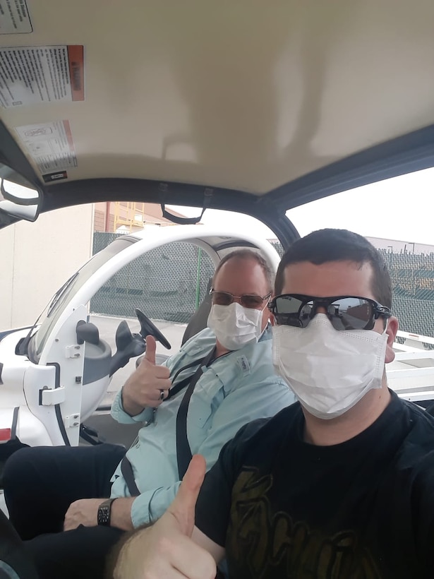 Mark Wittrock, Area/Resident Engineer Bahrain and Capt. Grant Wanamaker, project manager forward, use personal protective equipment traveling to and from the office.