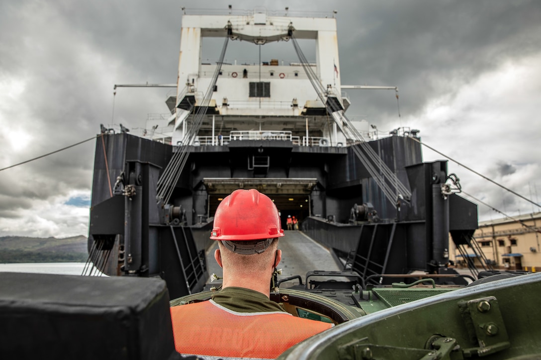 NAVAL BASE GUAM (April 16, 2020) U.S. Marine Corps Cpl. Connor Kretchman, an Amphibious Assault Vehicle (AAV) mechanic with General Support Maintenance Company, 3rd Transportation Support Battalion, 3rd Marine Logistics Group, drives an AAV-P7/A1 amphibious assault vehicle onto the Watson-class vehicle cargo ship USNS Dahl (T-AKR-312) during an operation to onload and offload equipment for construction of an Expeditionary Medical Facility (EMF). The EMF will provide expanded medical capabilities in support of DoD’s COVID-19 response and will enable forces to be postured to support Guam and the region if a Defense Support of Civil Authorities mission is requested. (U.S. Marine Corps photo by Sgt. Hailey D. Clay)