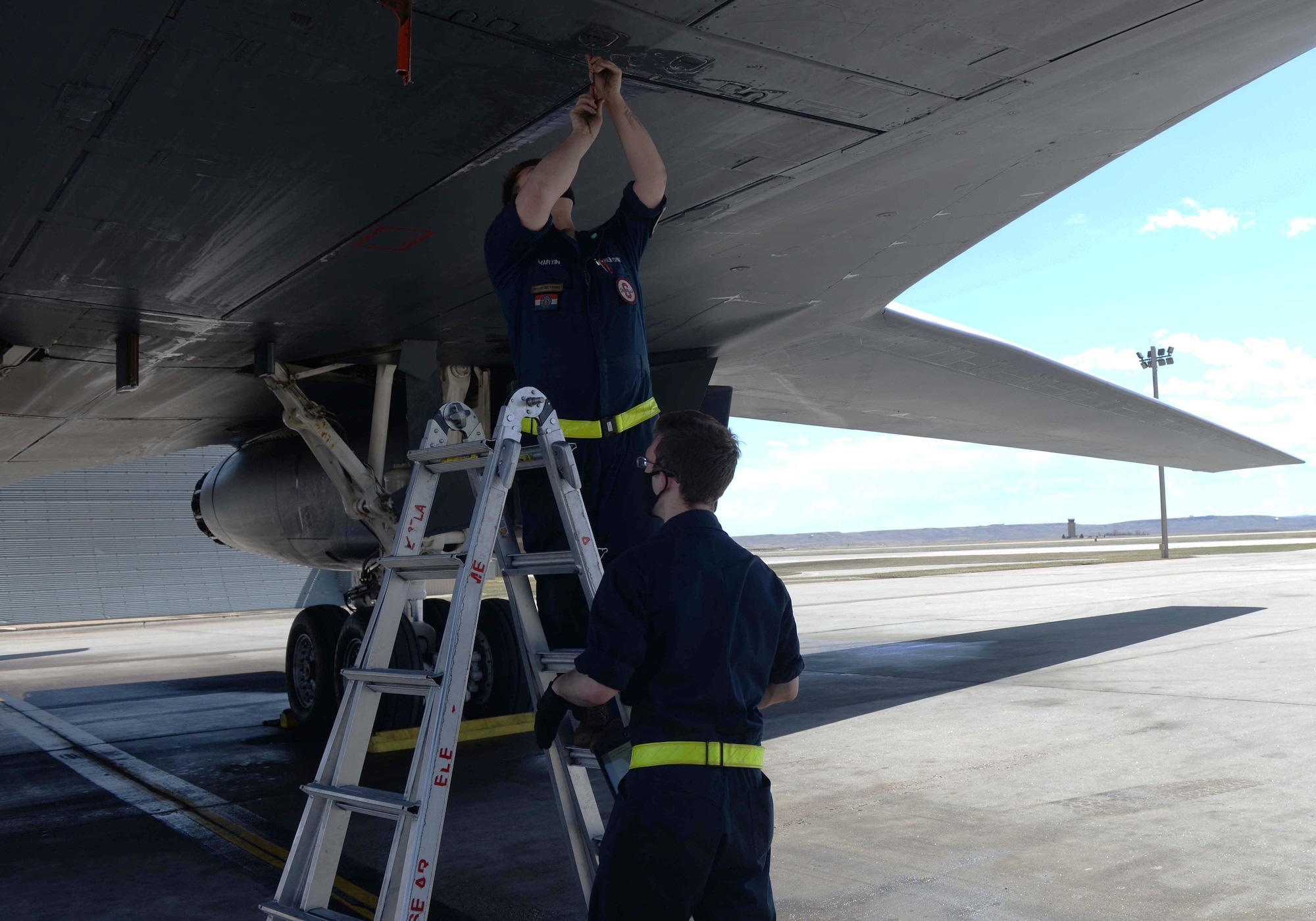 Maintainers assigned to the 28th Aircraft Maintenance Squadron fasten a panel on a B-1B Lancer at Ellsworth Air Force Base, S.D., April 22, 2020.
