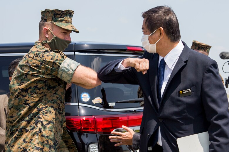 沖縄県の謝花喜一郎副知事が普天間基地司令官のデイビッド・スティール大佐と握手の代わりの肘とひじを合わせました。副知事は４月10日発生した普天間基地からの泡消火剤の基地外流出で、現場を訪れ、基地関係者から説明を受けました。