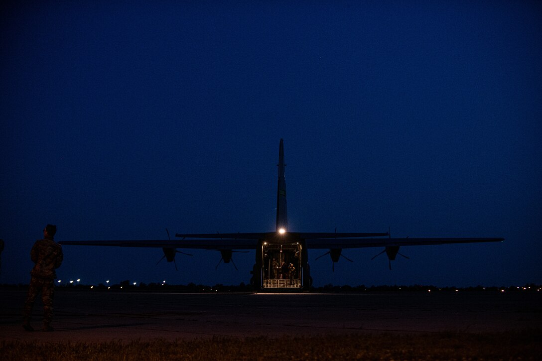 Airmen and Soldiers load cargo on a C-130J