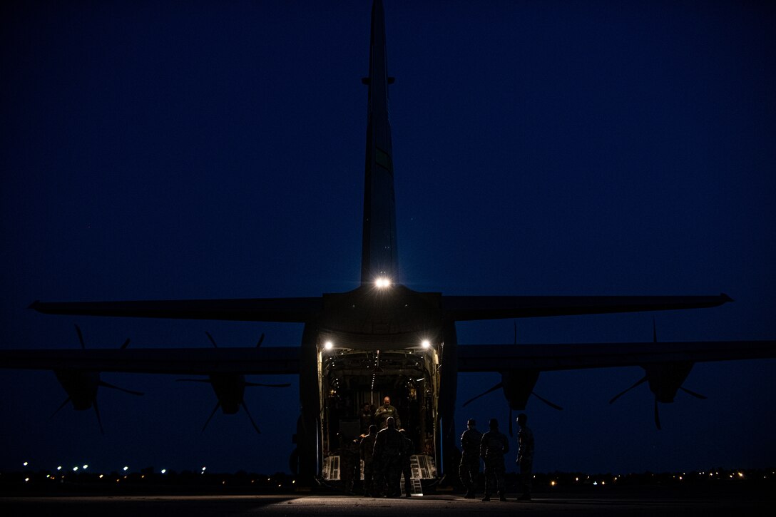 Airmen and Soldiers load cargo on a C-130J