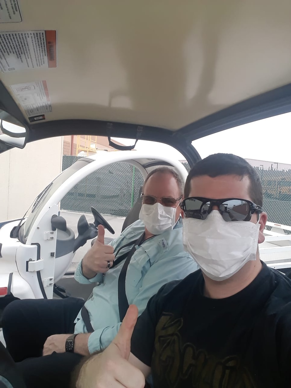 Two men riding around while wearing face masks.