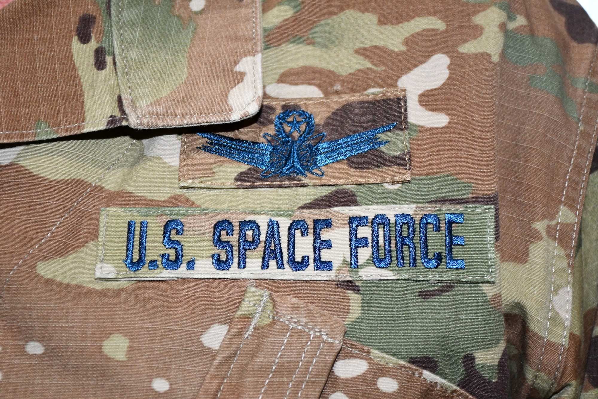 U.S. Air Force Airmen who transfer into the U.S. Space Force will continue to wear the Operational Camouflage Pattern utility uniform currently worn by USAF and U.S. Army personnel, but with distinct blue thread and a colored U.S. flag on the left arm. The USSF is the sixth branch of the U.S. Armed Forces and is part of the Department of the Air Force.