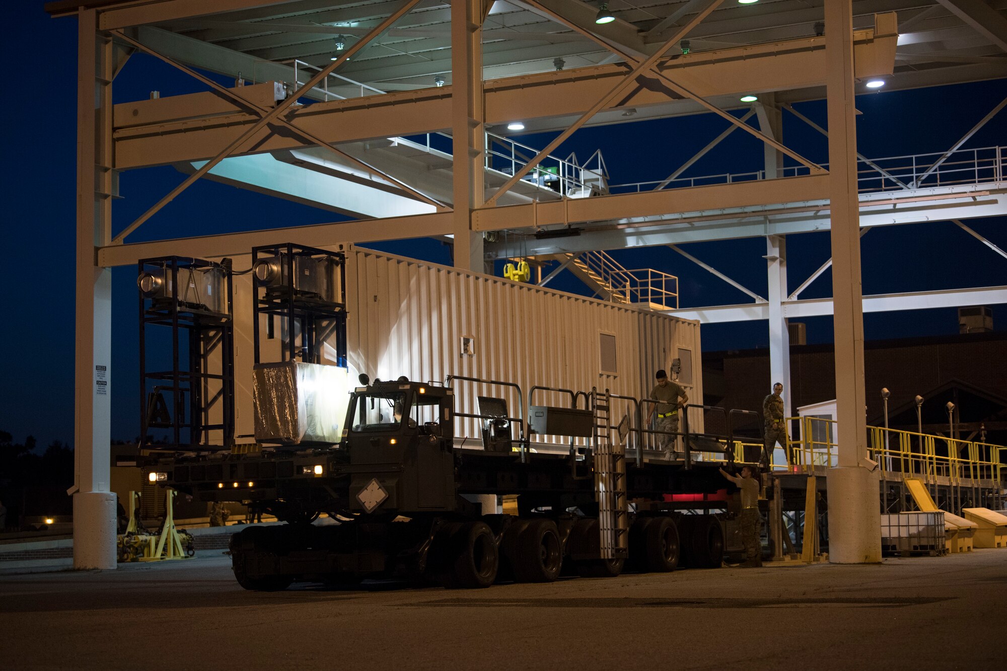 U.S. Airmen from the 437th Aerial Port Squadron use a K-Loader to move a Negatively Pressurized Conex prototype after it was delivered to Joint Base Charleston, S.C., April 21, 2020. The NPC will be tested for potential use as a transport module for individuals infected with the COVID-19 virus and other highly infectious diseases. (U.S. Air Force photo by Staff Sgt. Chris Drzazgowski)