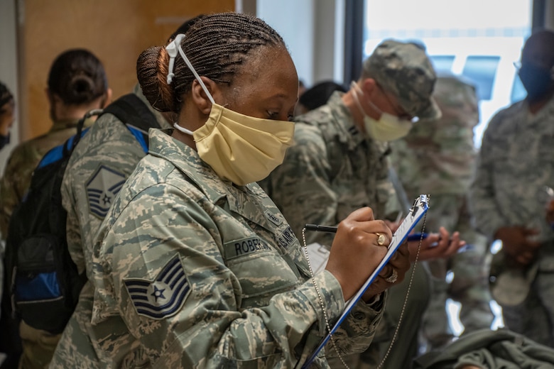 Tech. Sgt. Cynitra Roberson, 307th Medical Squadron technician, fills out paperwork at Barksdale Air Force Base, Louisiana,  before deploying to New York to aid local medical personnel in their battle with COVID-19. (2nd Lt. Cody Burt)