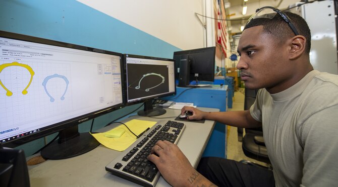U.S. Air Force Senior Airman James White, 52nd Maintenance Squadron aircraft metal technology journeyman, looks at the detailed plans for 3-D printed face shield frames at Spangdahlem Air Base, Germany, April 9, 2020. Airmen are going outside of their normal job duties to design and perfect the production of these face mask to make sure that Spangdahlem AB and the local community are prepared if they are called upon to mass produce face shields. (U.S. Air Force photo by Airman 1st Class Branden Rae)
