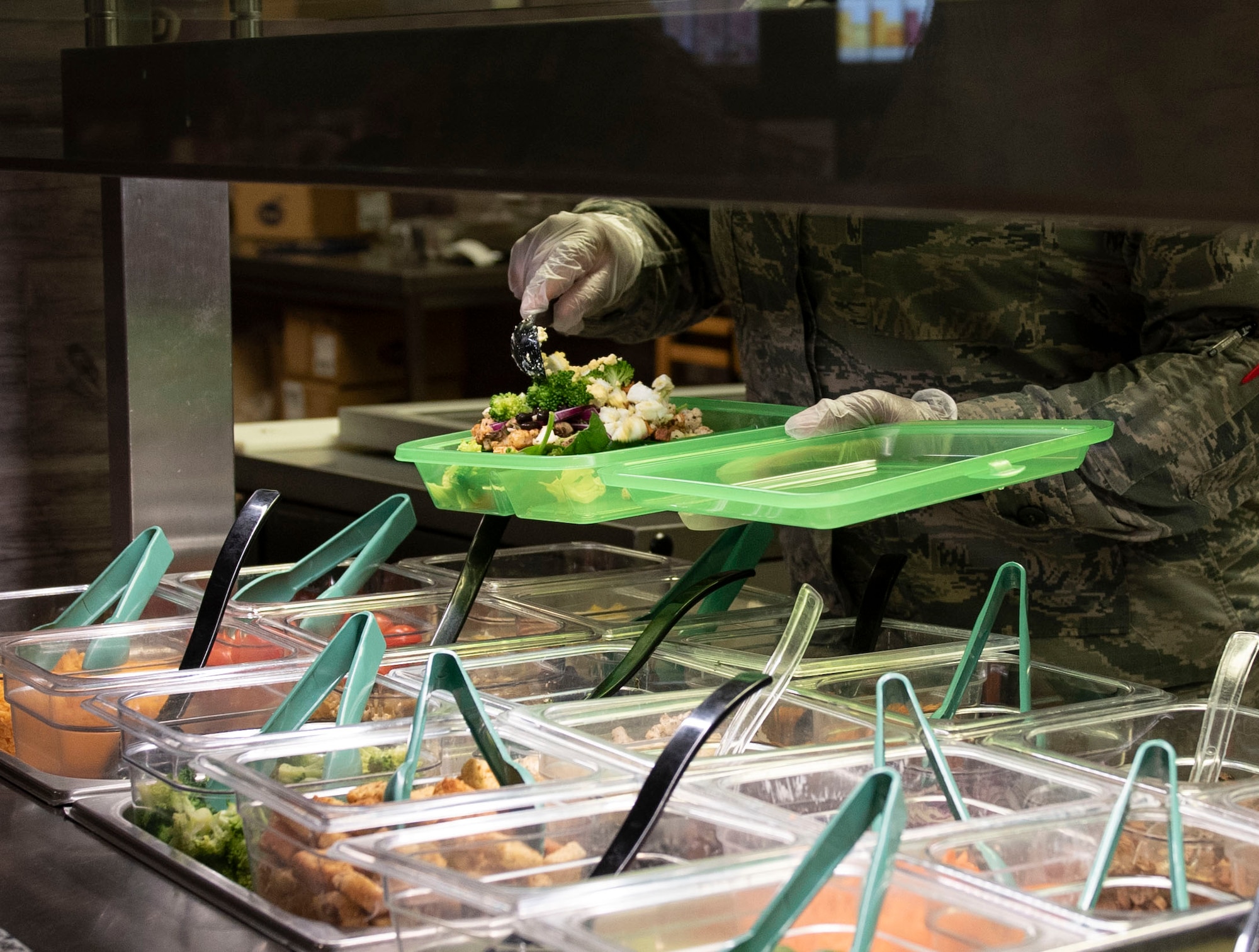 U.S. Air Force Senior Airman Joniece Guerrero, 52nd Force Support Squadron food service journeyman, prepares a food order at Spangdahlem Air Base, Germany, April 20, 2020.
OZZI trays were implemented to improve the quality of life and work centers for Airmen and families. (U.S. Air Force photo by Senior Airman Melody W. Howley)