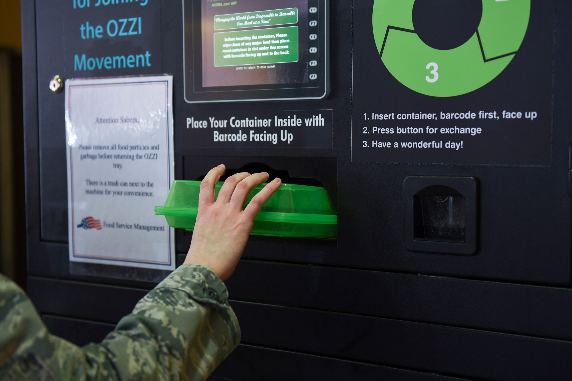 U.S. Air Force Airman 1st Class Leiah Copeland, 52nd Force Support Squadron food service journeyman, places a tray into an OZZI machine at Spangdahlem Air Base, Germany, April 20,
2020. OZZI meal trays were implemented in the dining facility to help save money, conserve resources and reduce waste. (U.S. Air Force photo by Senior Airman Melody W. Howley)