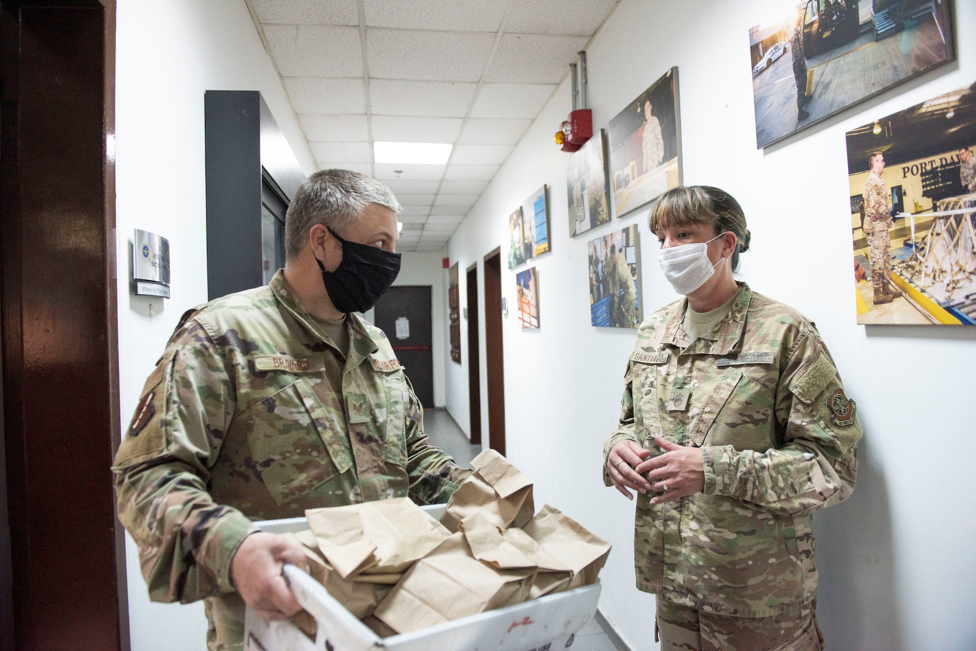 Photo of two Airmen talking in a hallway
