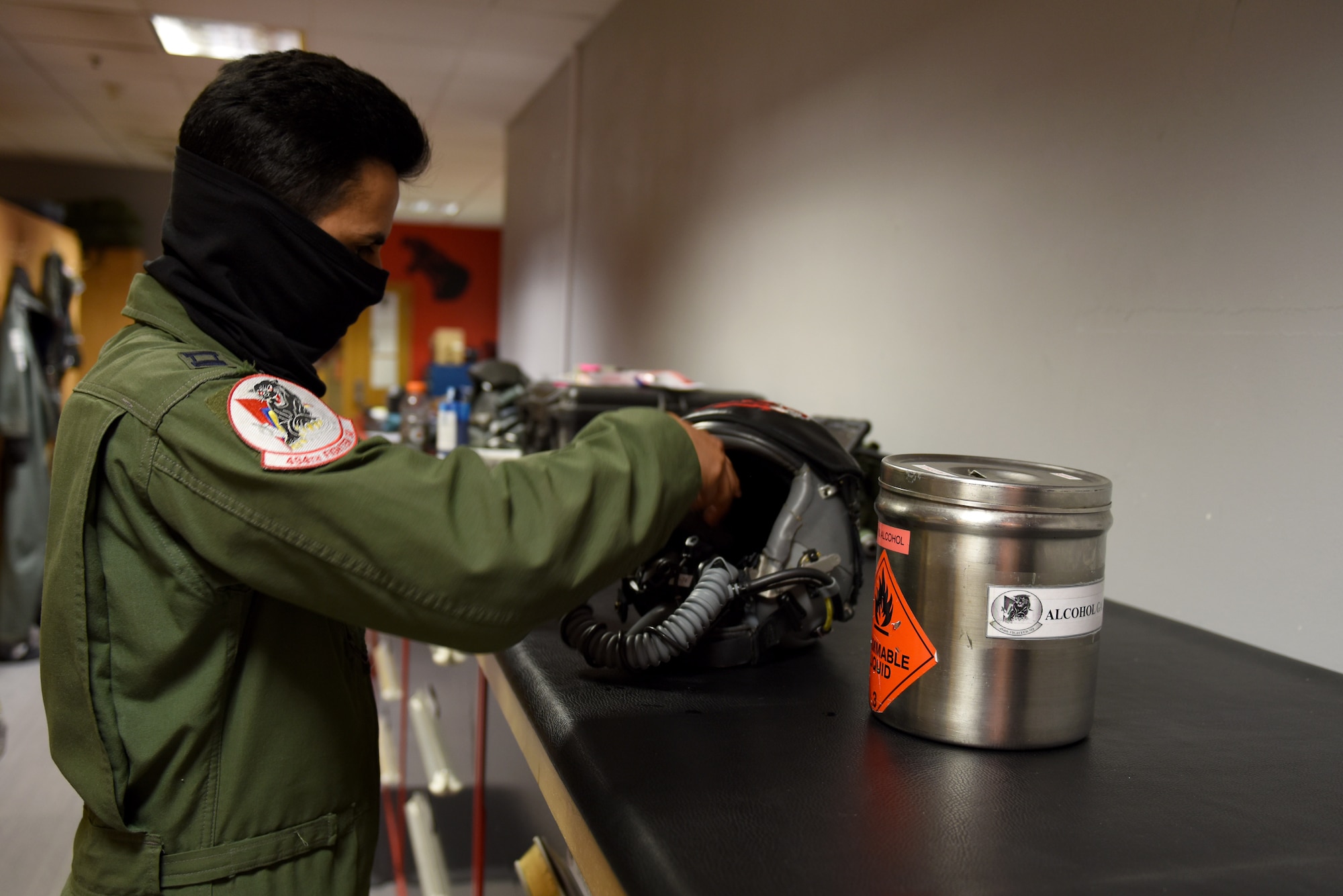 A pilot assigned to the 494th Fighter Squadron cleans his flight helmet at Royal Air Force Lakenheath, England, April 22, 2020. Liberty Wing aircrew must clean their gear after each flight before handing it over to an Aircrew Flight Equipment technician to further sanitize the equipment to help stop the spread of COVID-19. (U.S. Air Force photo by Airman 1st Class Rhonda Smith)