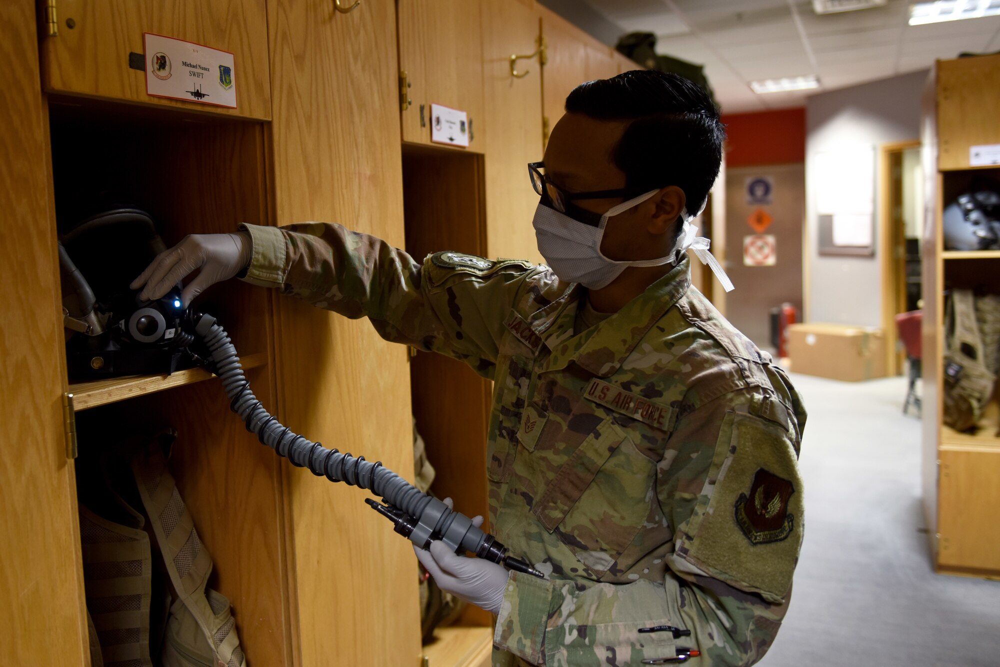 An Aircrew Flight Equipment Airman assigned to the 494th Fighter Squadron checks flight gear at Royal Air Force Lakenheath, England, April 22, 2020. AFE Airmen clean and disinfect surfaces, tools, testers, and non-expendable equipment items during continued operations despite the COVID-19 pandemic. (U.S. Air Force photo by Airman 1st Class Rhonda Smith)