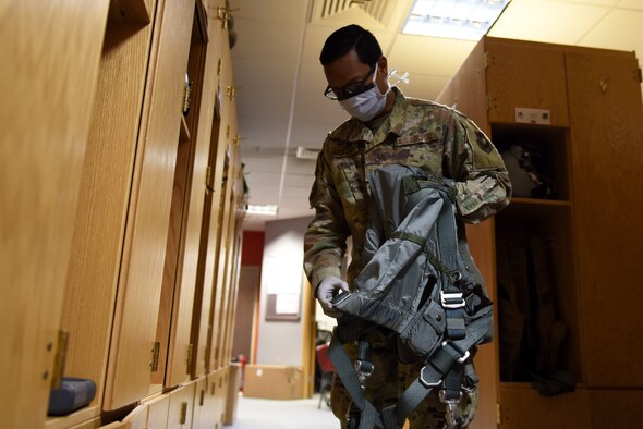 An Aircrew Flight Equipment Airman assigned to the 494th Fighter Squadron checks flight gear at Royal Air Force Lakenheath, England, April 22, 2020. AFE technicians wear personal protective equipment such as masks and gloves to prevent the spread of COVID-19, while supporting ongoing operations and protecting Liberty Wing Airmen. (U.S. Air Force photo by Airman 1st Class Rhonda Smith)