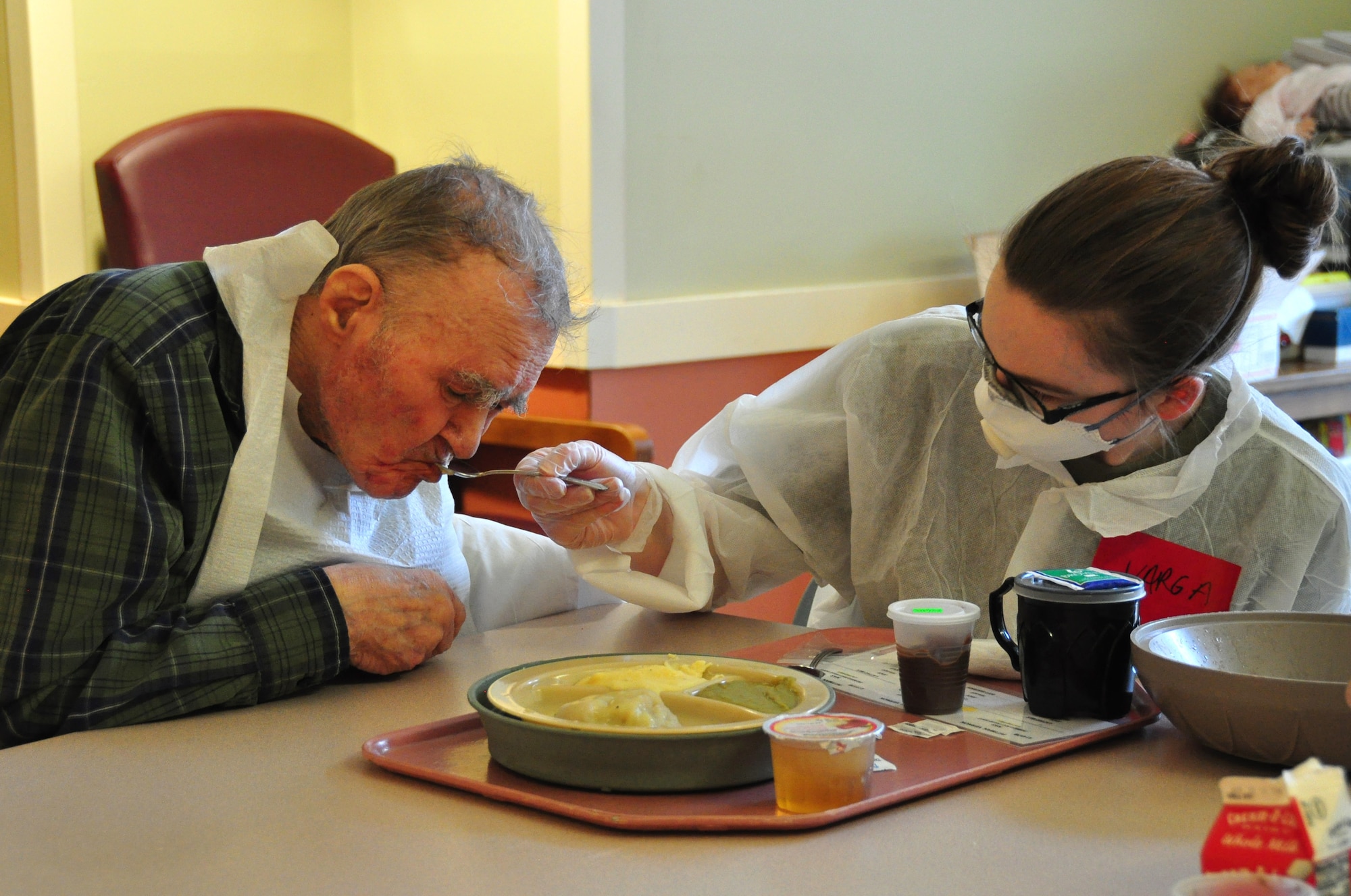 A picture of U.S. Army Pfc. Alexis Varga, a Combat Medic with the 1st Battalion, 114th Infantry Regiment, New Jersey Army National Guard, feeding a resident.