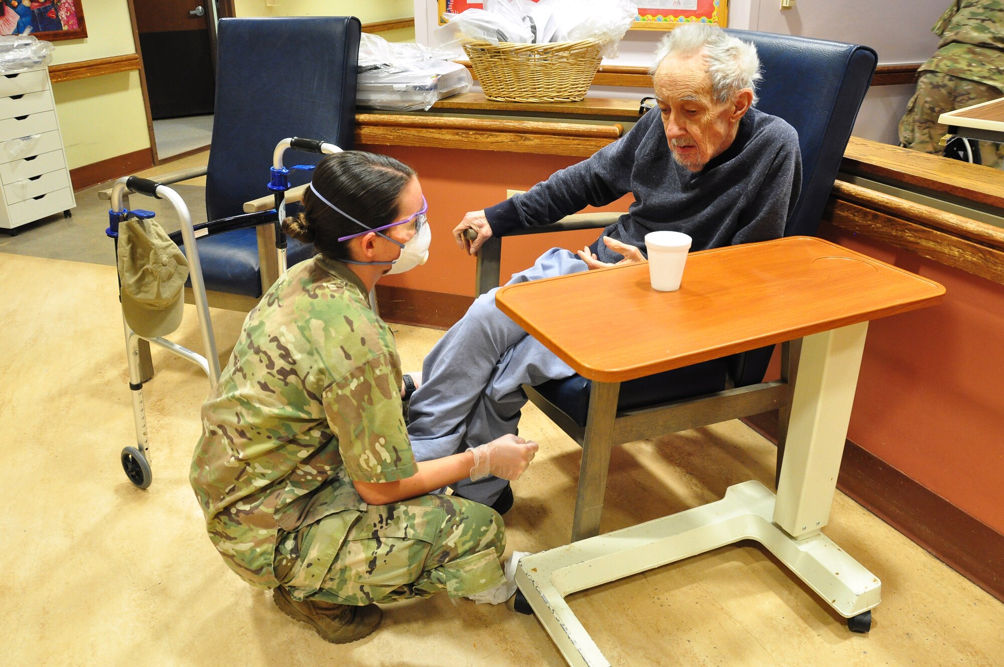 A picture of U.S. Army Spc. Laurel Yerg, a Combat Medic with the 1st Battalion, 114th Infantry Regiment, New Jersey Army National Guard, checking on a resident.